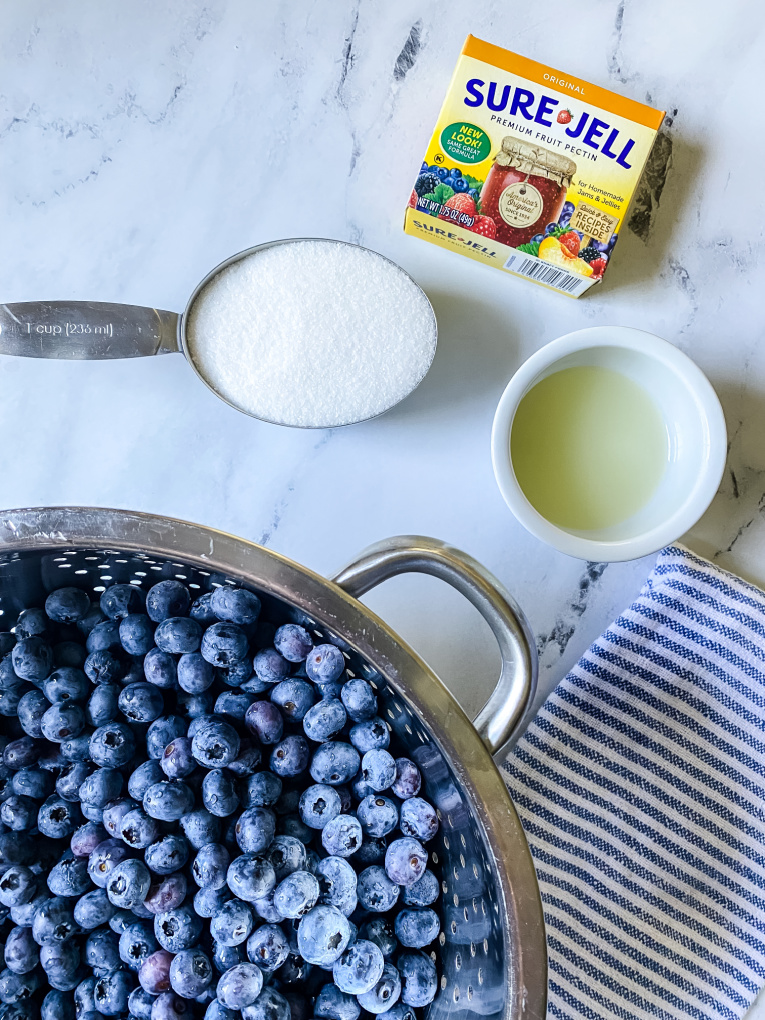 picture of blueberries in colander with a cup of sugar, lemon juice, and sure gel pectin