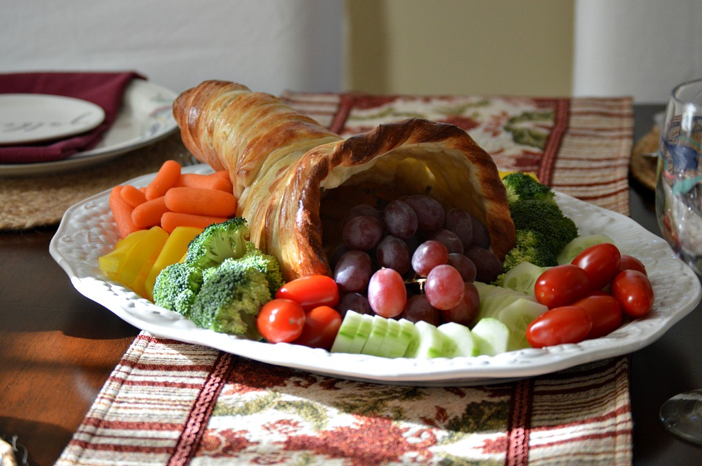 cornucopia made with bread, filled with fresh fruits and veggies