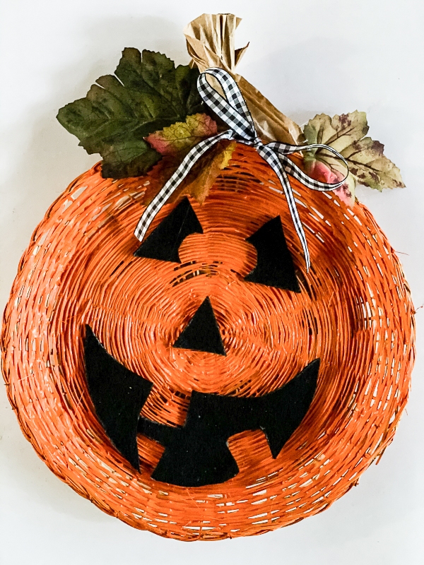 a jack-o-lantern pumpkin made with a wicker paper plate holder