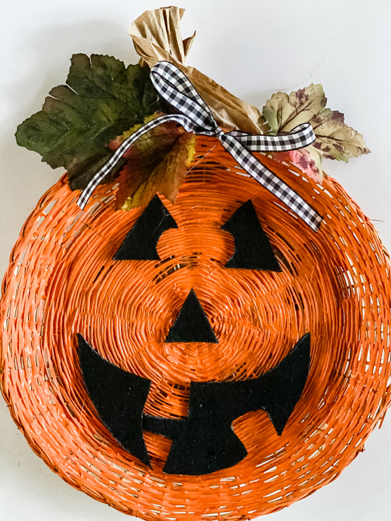 a jack-o-lantern pumpkin made with a wicker paper plate holder