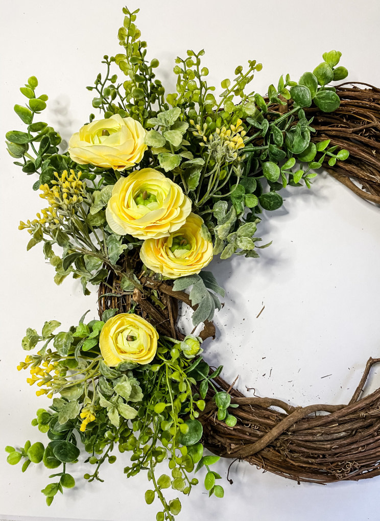 view of spring floral wreath being assembled with yellow rananculus