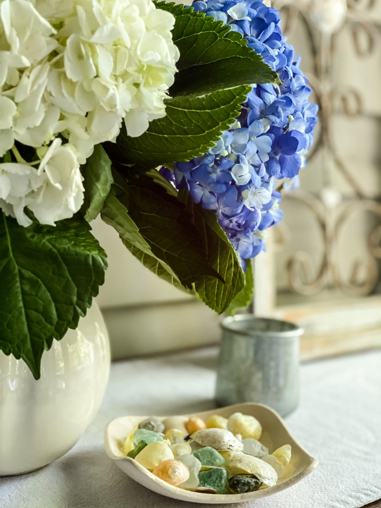 view of blue and white hydrangeas with diy candle holder and shells 