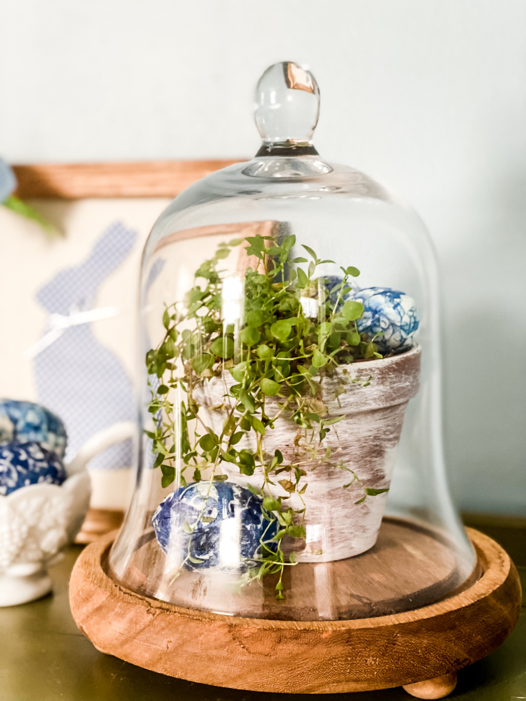 sharing spring decorating ideas with view of cloche with decoupage Easter eggs and plant