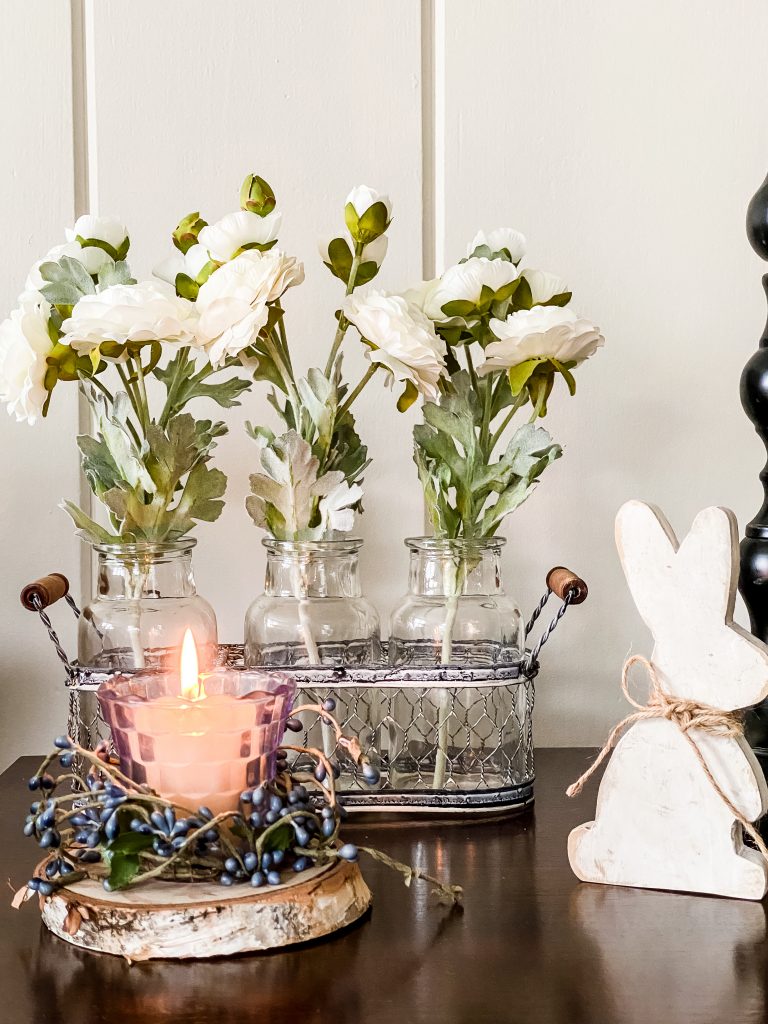 sharing spring decorating ideas with view of side table with candle, ranunculus, and bunny
