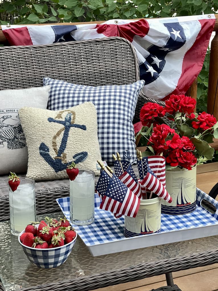 view of bench with nautical pillows and patriotic bunting in background