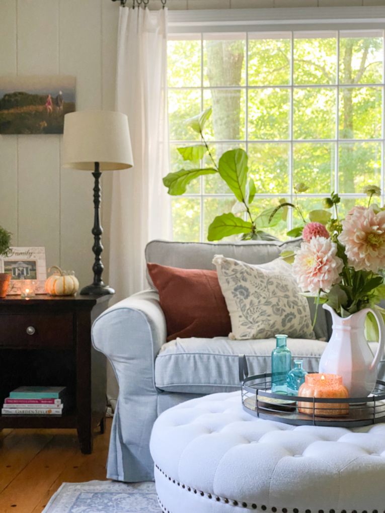 view of fall family room with blue couch and copper accents and fresh flowers
