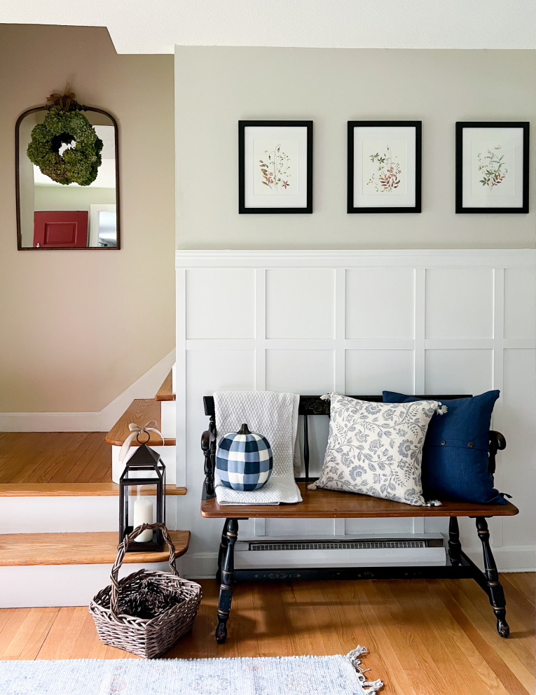 entryway with board and batten wall and bench decorated with blue and white for fall
