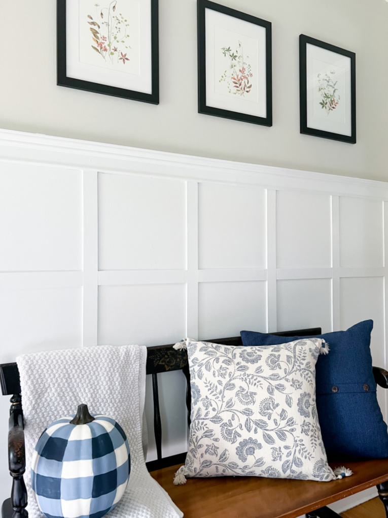 entryway with board and batten wall and bench decorated with blue and white for fall