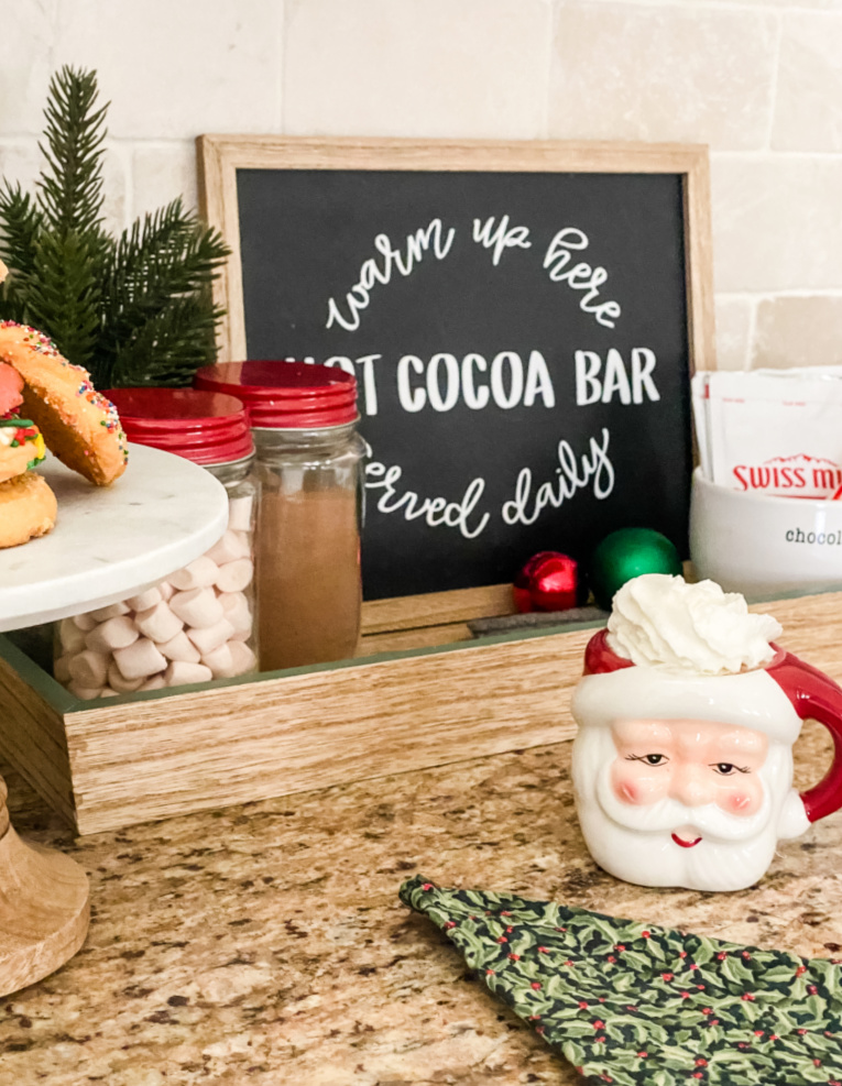 decorate your kitchen for Christmas with a hot cocoa bar with Santa mug filled with cocoa on counter