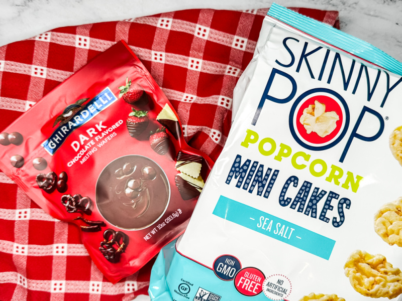 red and white towel and packages of Ghiradelli dark chocolate wafers and Skinny Pop mini rice cakes