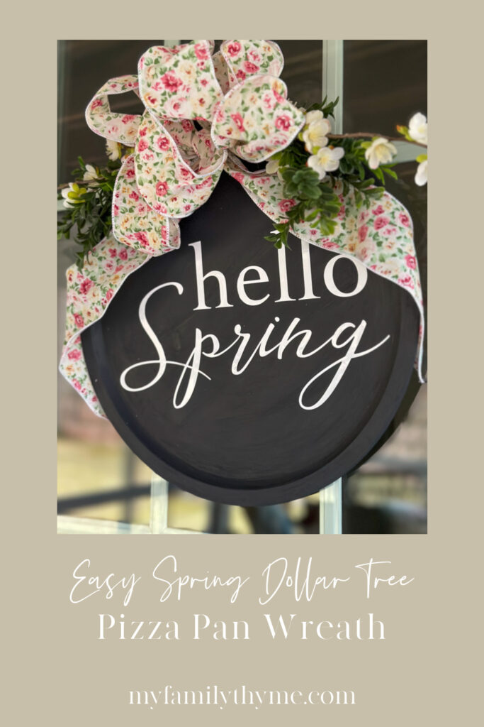 hello spring black painted pizza pan wreath with white lettering, floral bow, and greenery