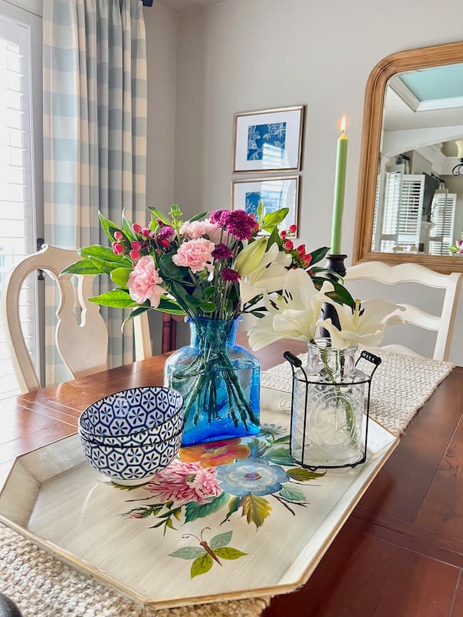 Spring table with blue vase of flowers on a flowered tray