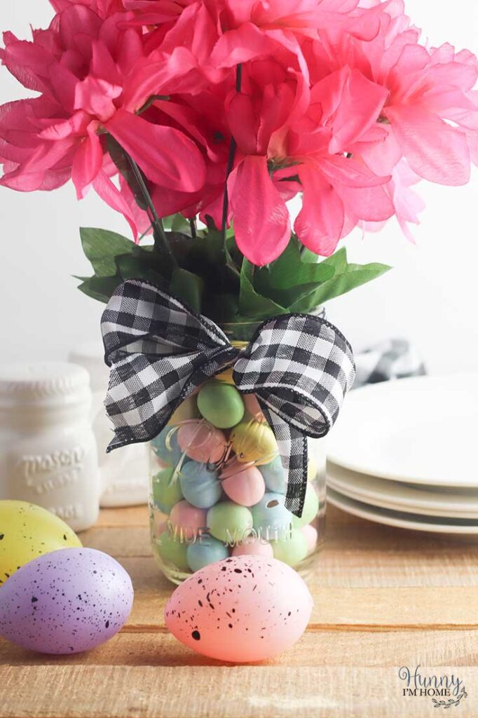 Mason jar Easter centerpiece with Cadbury eggs and black and white gingham ribbon