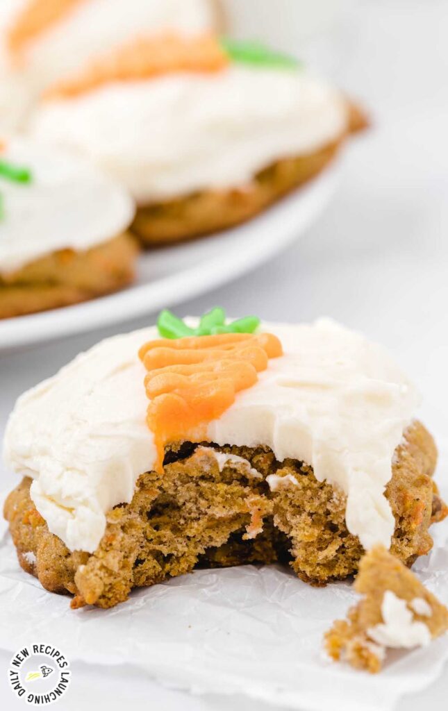 carrot cake cookie with cream cheese frosting, with a bite taken out.