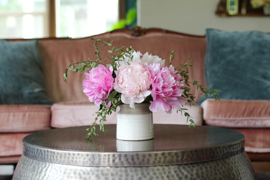 pink peony arrangement on coffee table with greeenery
