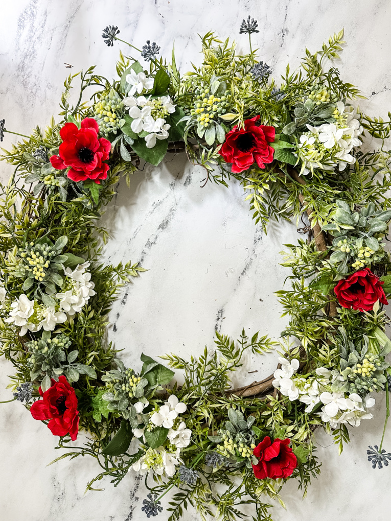 DIY summer red white and blue floral wreath on a marble table top