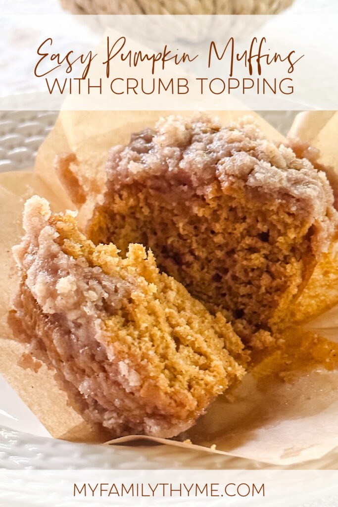 baked pumpkin muffin with crumb topping cut in half, with muffin liner peeled away